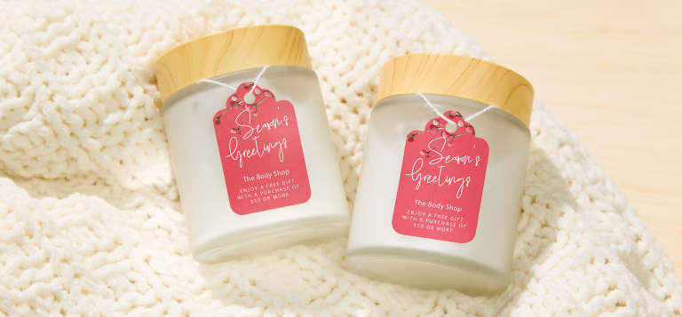 Printable DIY holiday gift tags tied to candle jars, showing how custom gift tags can be printed and used for handmade products or gifts.