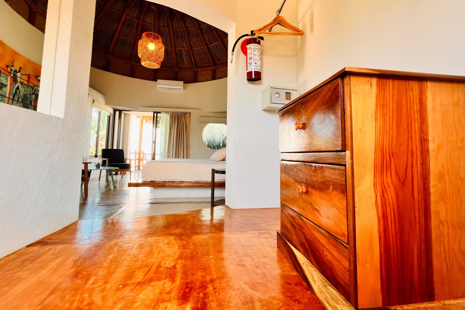 Cómoda de madera y cama al fondo