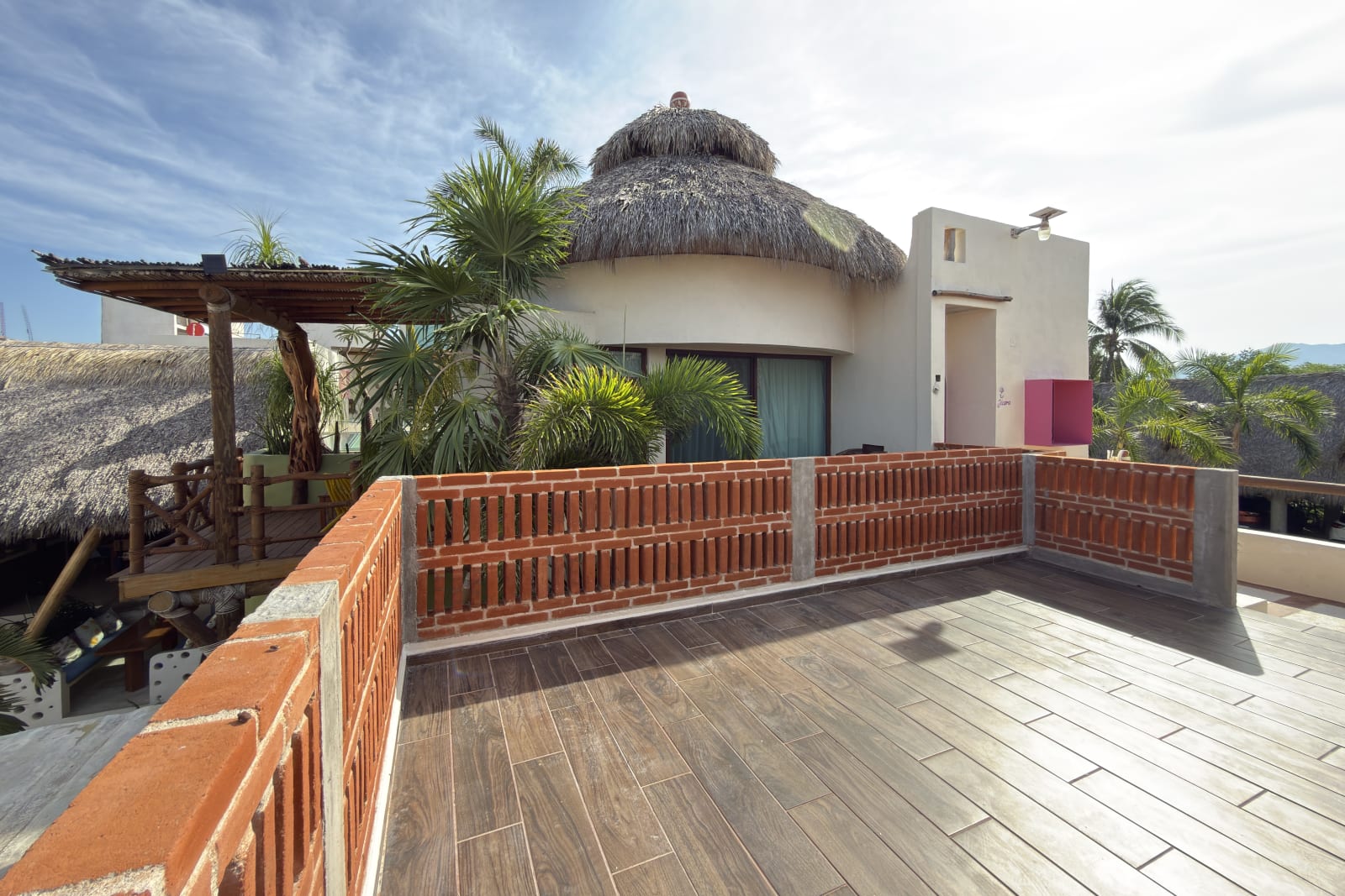 Habitación Jícara: construcción redonda con techo de palapa y terraza de madera