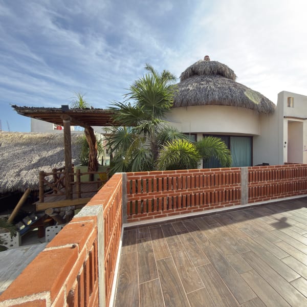 Habitación Jícara: construcción redonda con techo de palapa y terraza de madera