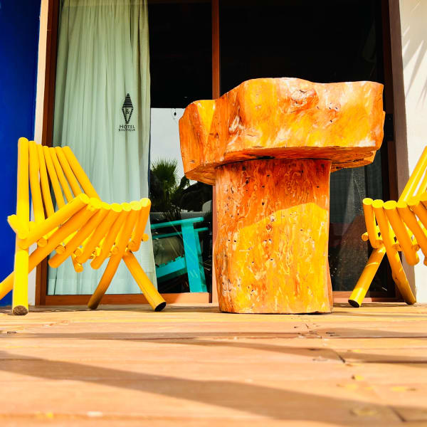 Terraza de la habitación Semilla con sillas amarillas y mesa de tronco