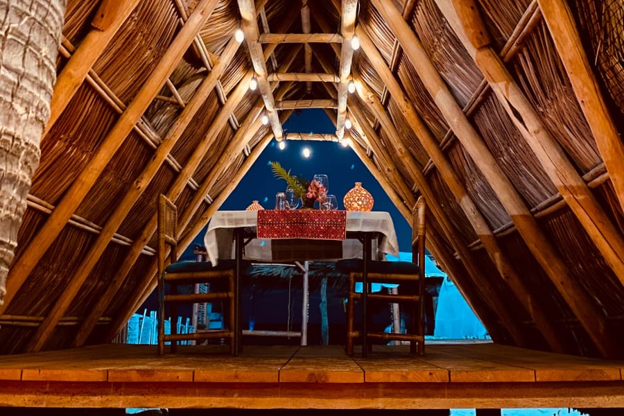 Mesa con velas bajo la palapa de noche