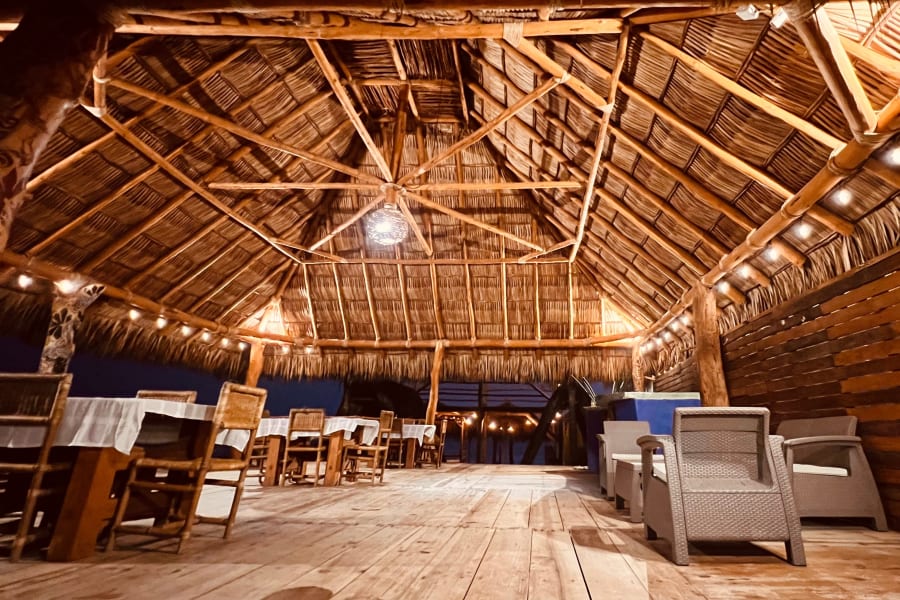 Comedor del club de playa bajo la palapa de noche