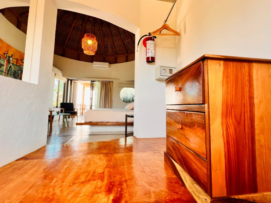 Cómoda de madera y cama al fondo