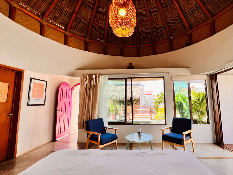 Cama y sala bajo la cúpula de palapa