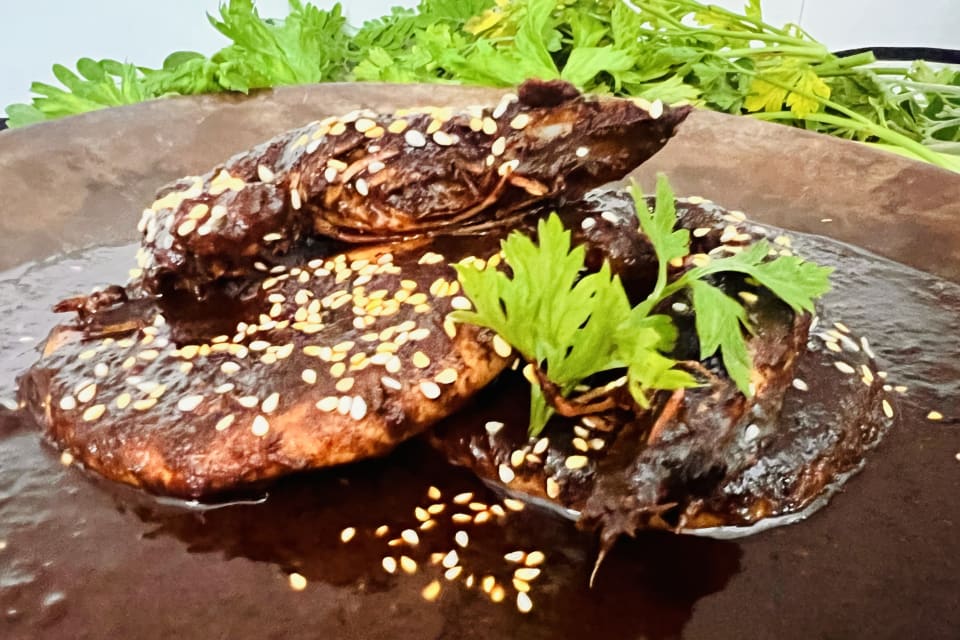 Camarones bañados en mole negro con ajonjolí y cilantro