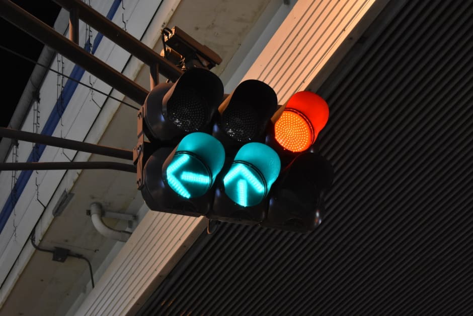 Green arrow and red traffic light in urban landscape