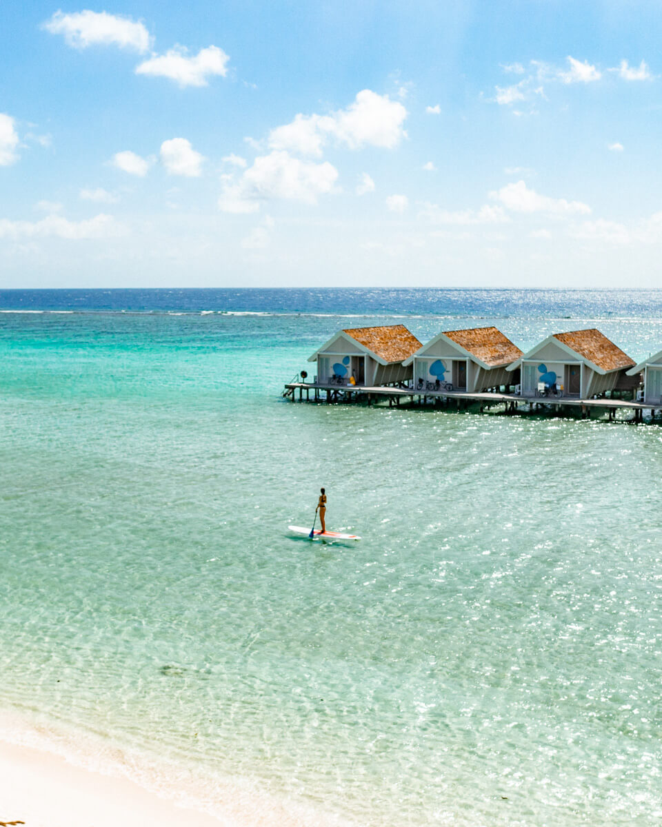 встаньте, гребите в голубой лагуне на Мальдивах гребите в голубой бухте Мальдивы