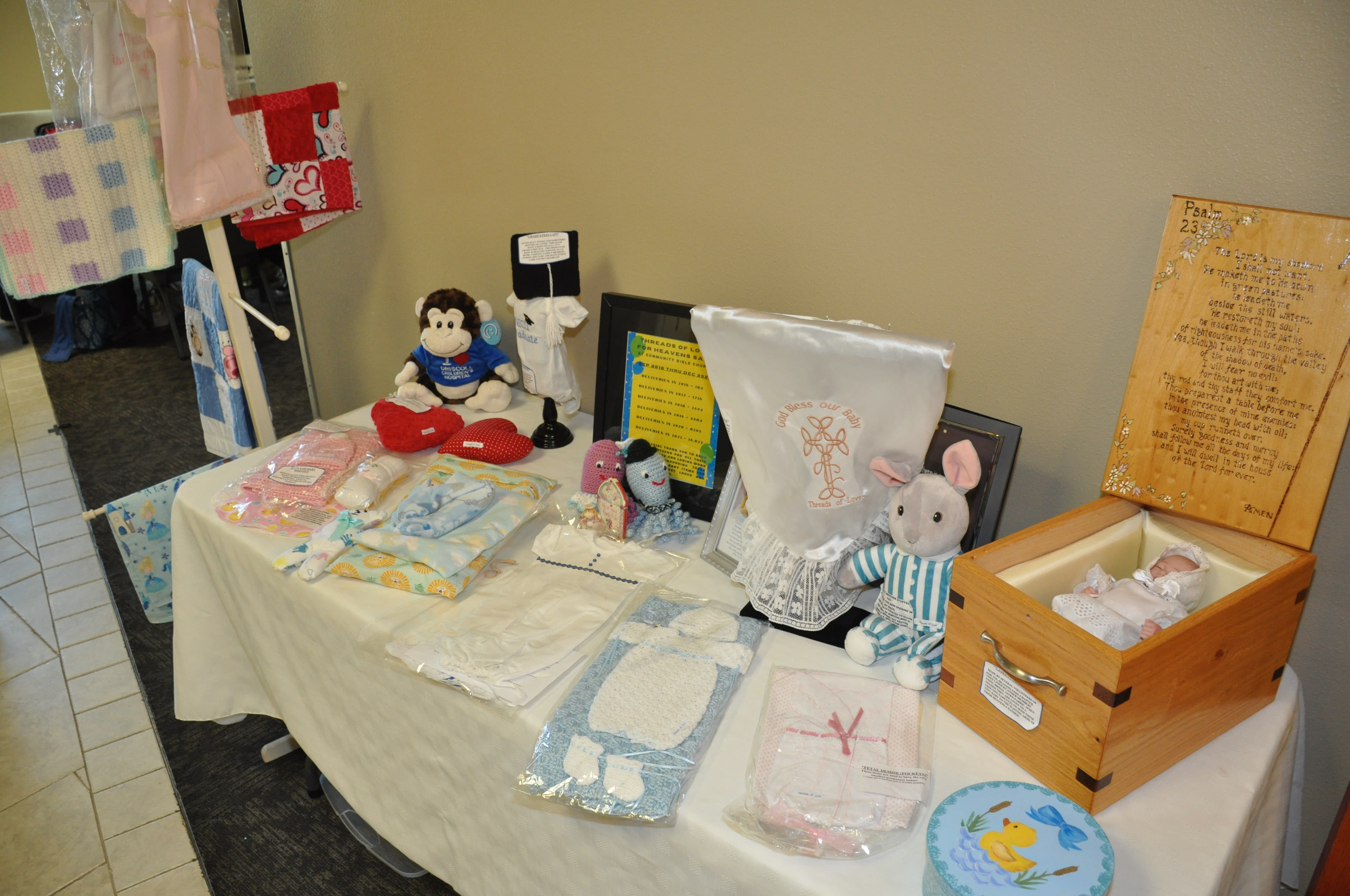 Threads of Love Baby products displayed on a table