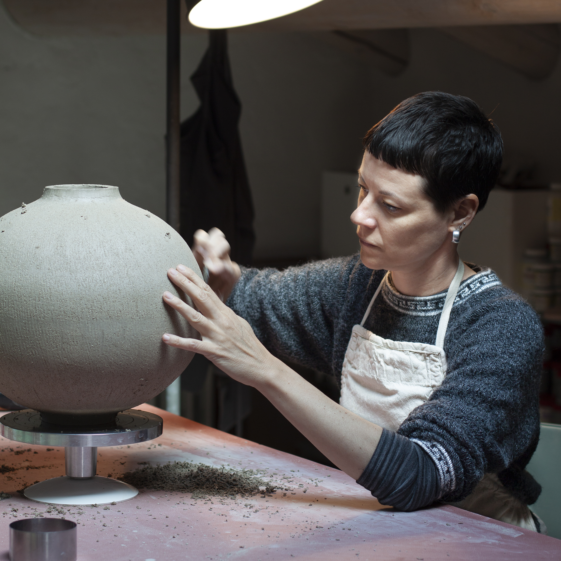 Elena Milani smoothing the surface of a large round vase
