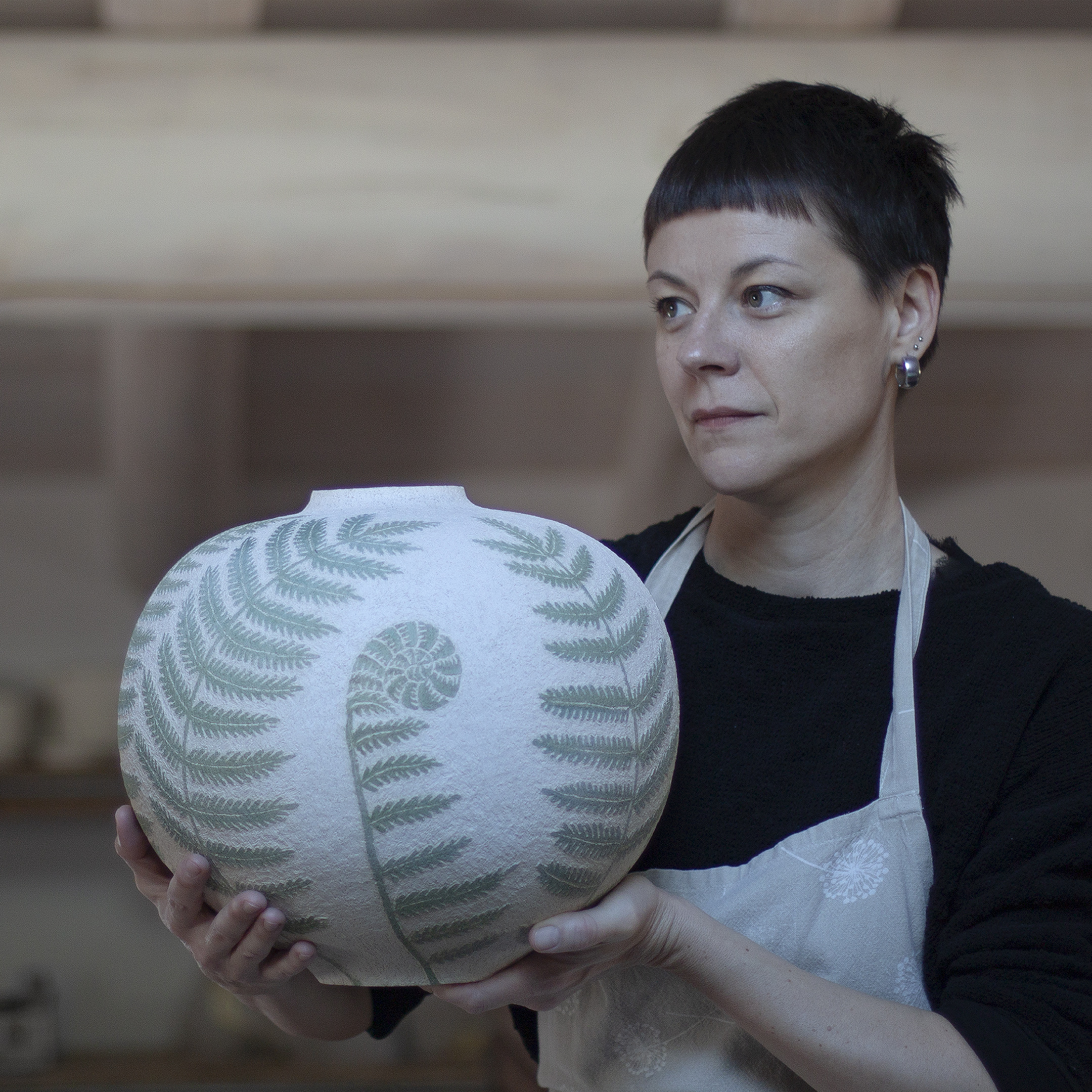 Elena Milani holding a finished fern-decorated vase
