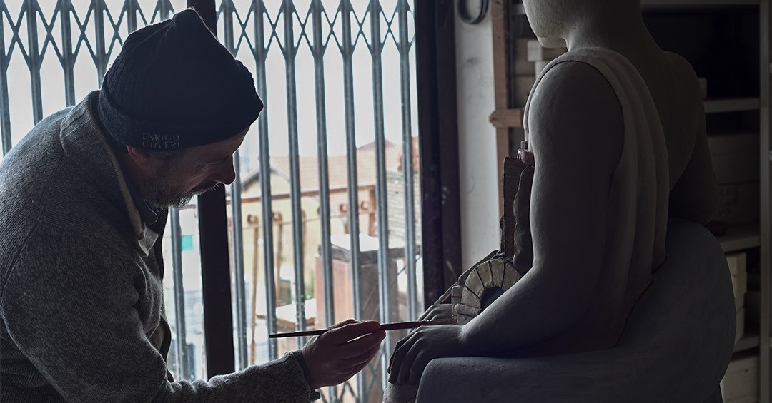 Maestro Filadelfio Todaro sculpting and finishing a ceramic figure in the studio window light