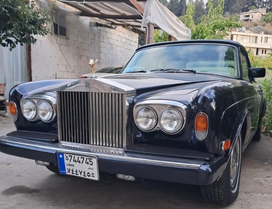 Dark blue Rolls-Royce Corniche with the top up and its chrome grille