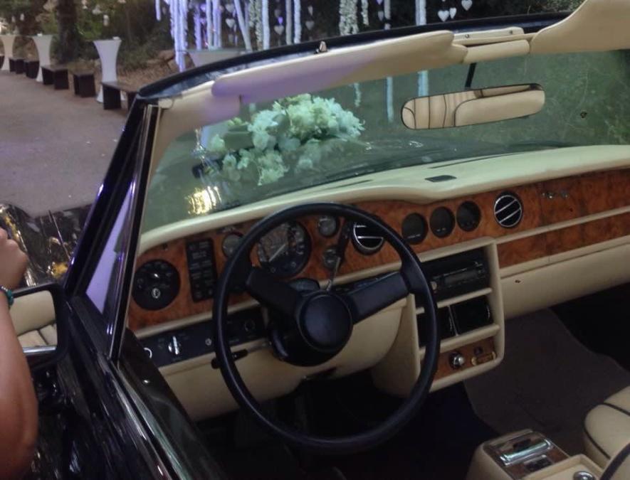 Wood dashboard and steering wheel of the Rolls-Royce Corniche, flowers on the hood