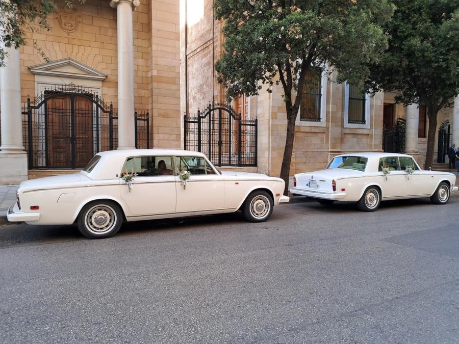 Two white Rolls-Royce Silver Shadows outside an old stone building