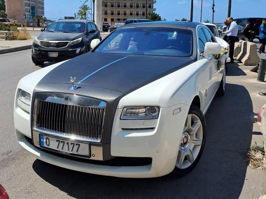 White Rolls-Royce Ghost with black hood and roof, front three-quarter view