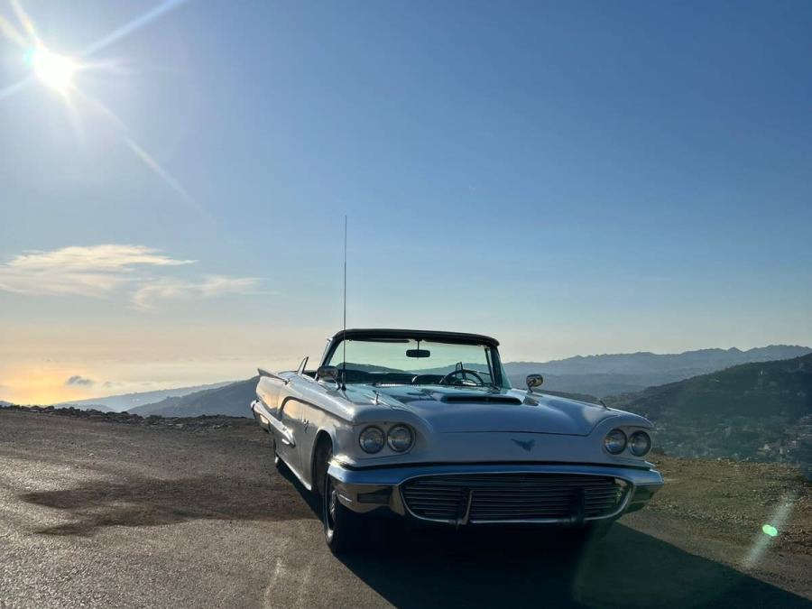 1960 Ford Thunderbird convertible with the top down at a mountain viewpoint