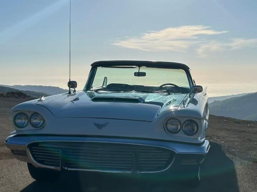 Front view of the 1960 Ford Thunderbird convertible, top down, with mountains behind