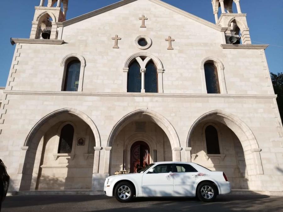 White Chrysler 300C in front of a stone church
