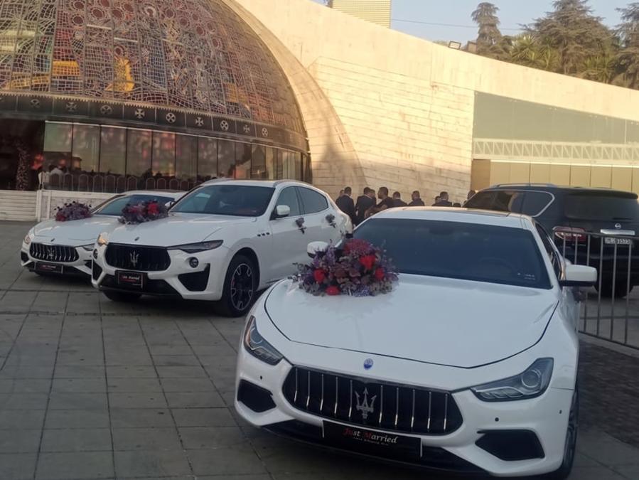 Convoy of white Maseratis at Bkerki, the lead car decorated with red roses