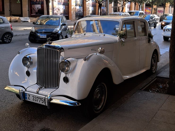 White 1953 Bentley R Type, front three-quarter view on a city street