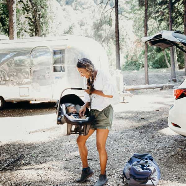 parent with baby in car seat in nature