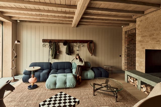 A woman relaxes on the sofa in the Coach House
