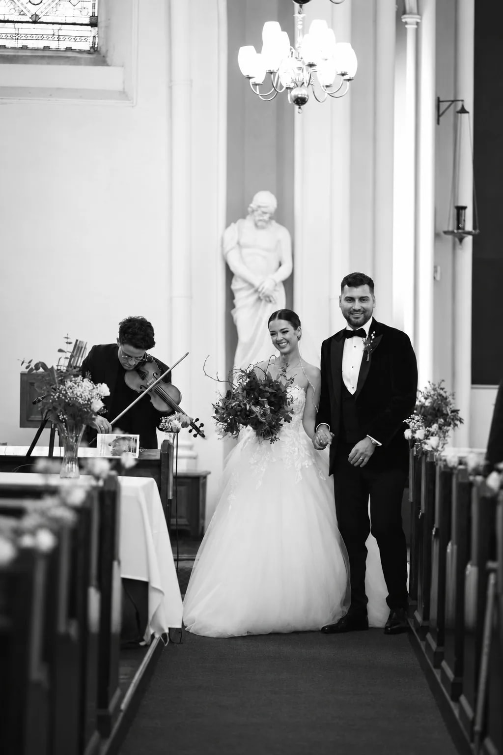 A bride and groom walking back down the aisle as Joel Grainger plays