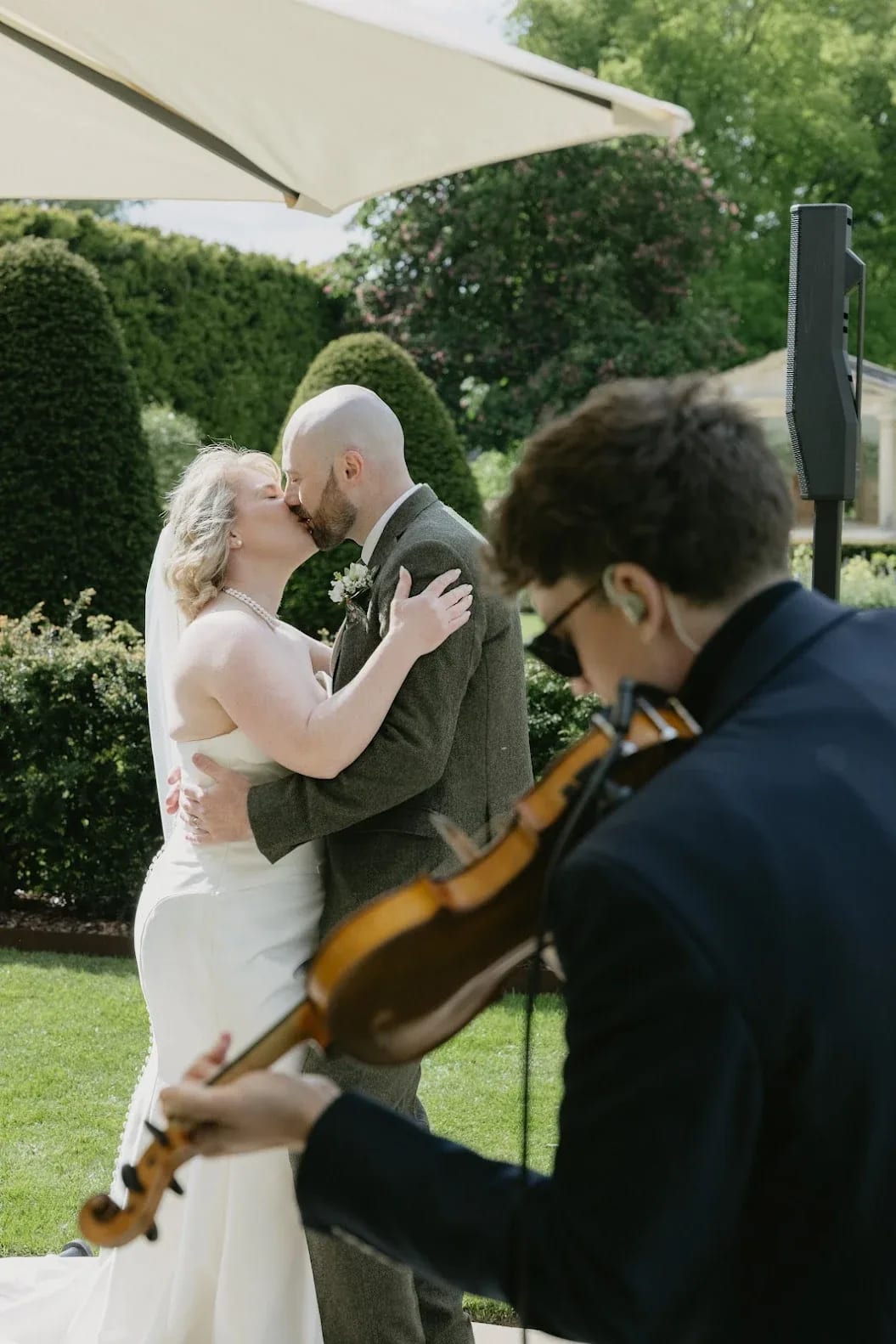 Joel Grainger playing violin at a garden Wedding ceremony