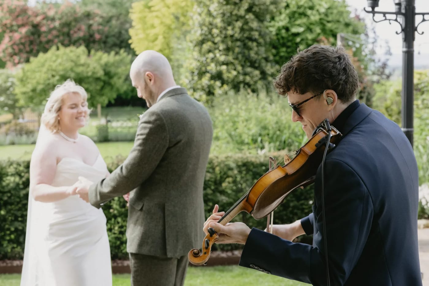Joel Grainger playing during an outdoor garden ceremony