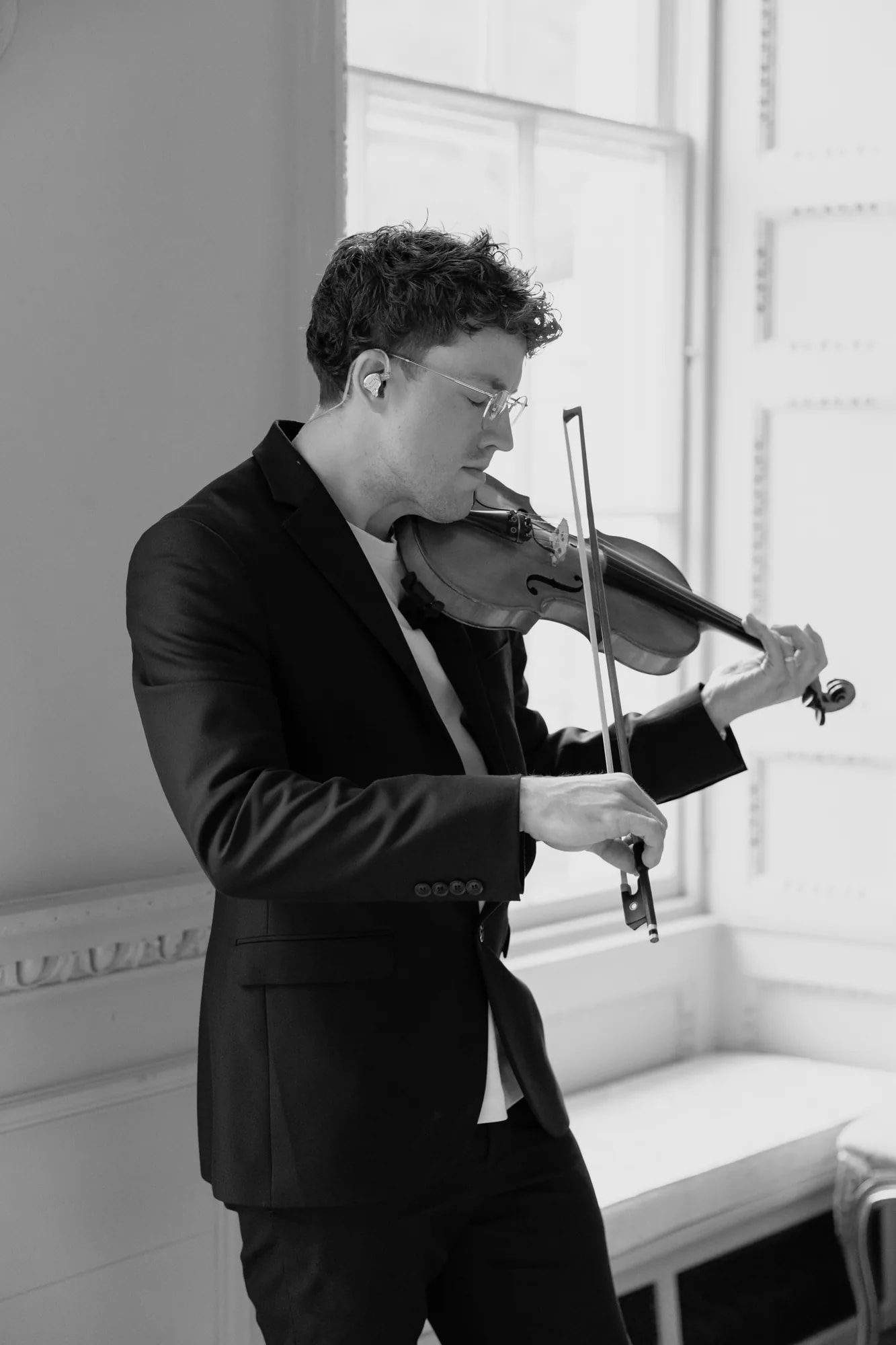 Joel Grainger with his violin in window light