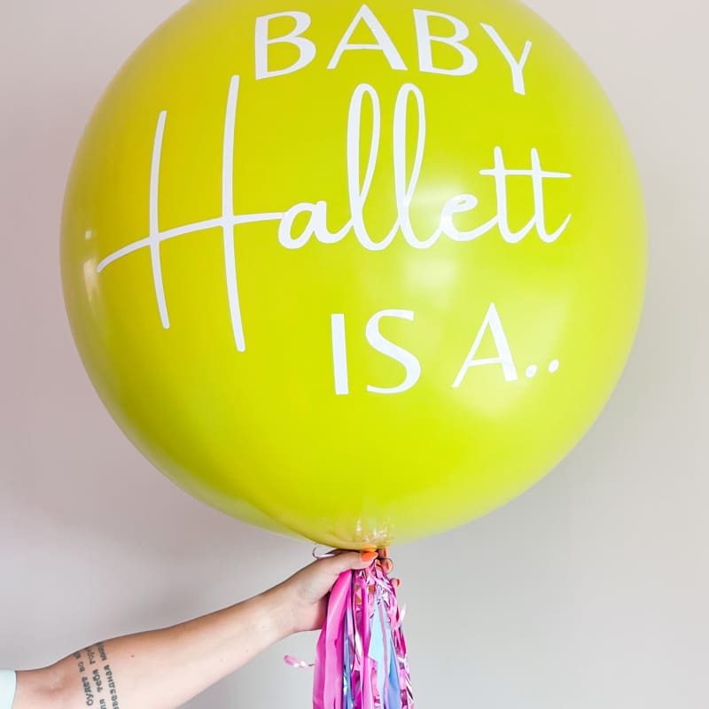 a person holding a yellow balloon with the words baby hallett is a written on the bottom of it
