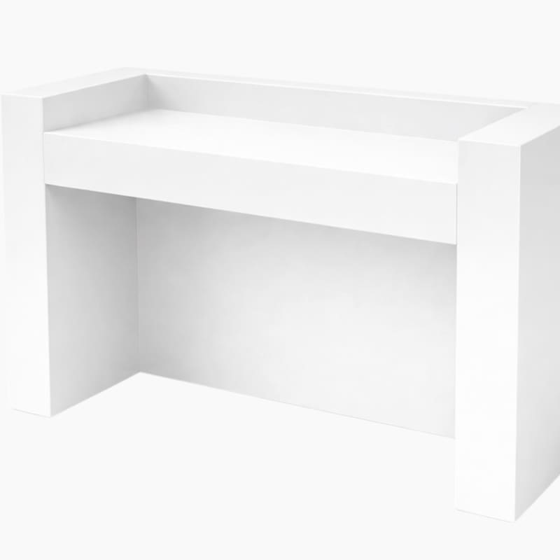 A simple, white rectangular structure with an open interior space.