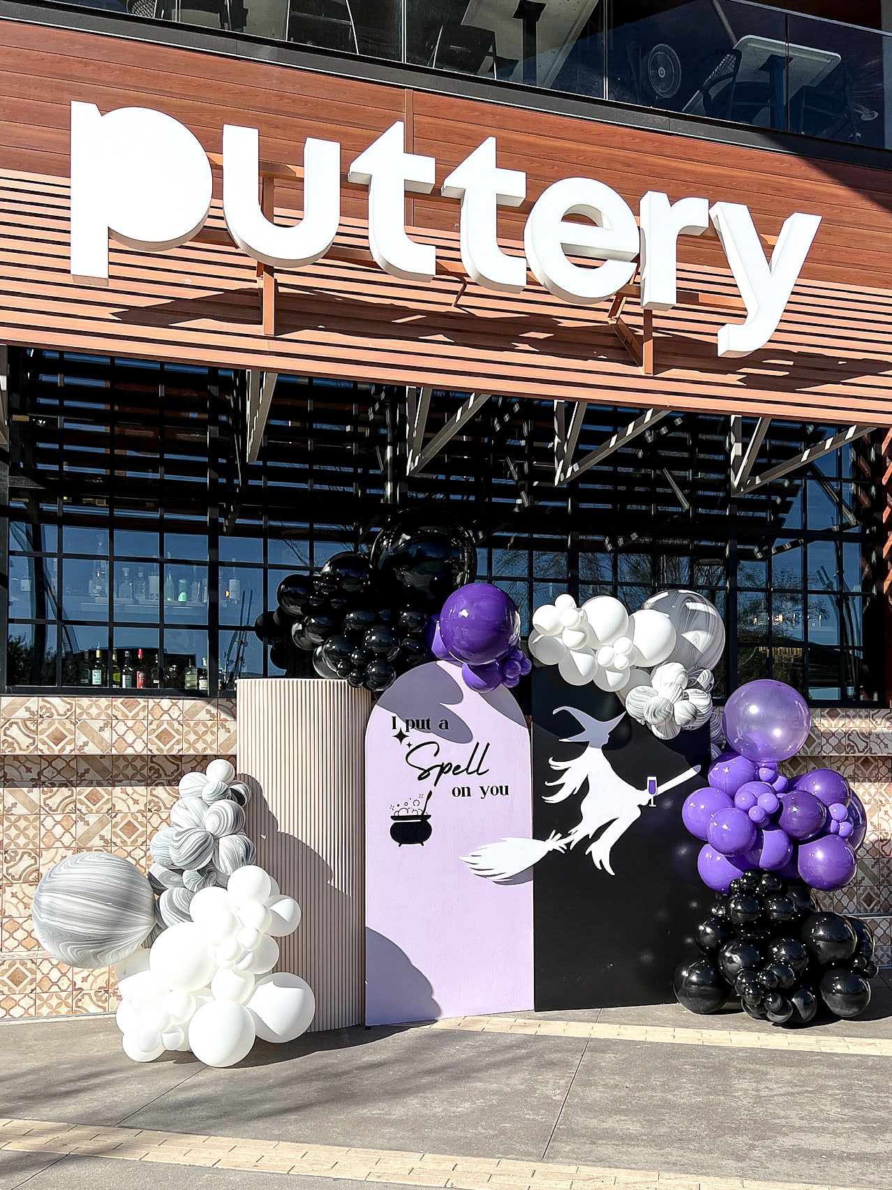 A large sign reading "Puttery" is prominently displayed on the exterior of a building, with various decorative balloons and displays in the foreground.