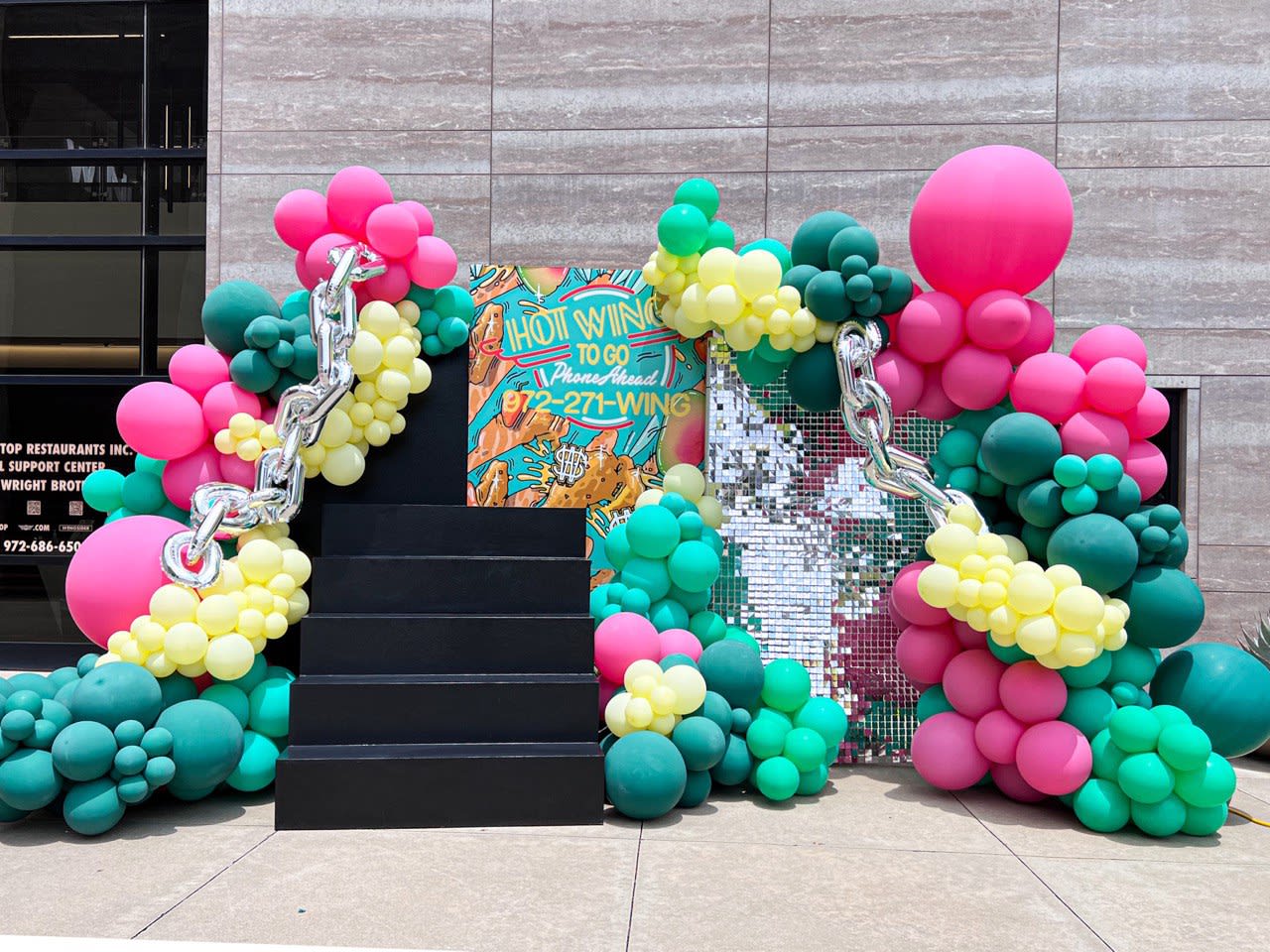 a group of balloons that are on the ground in front of a building with a sign that says do not enter