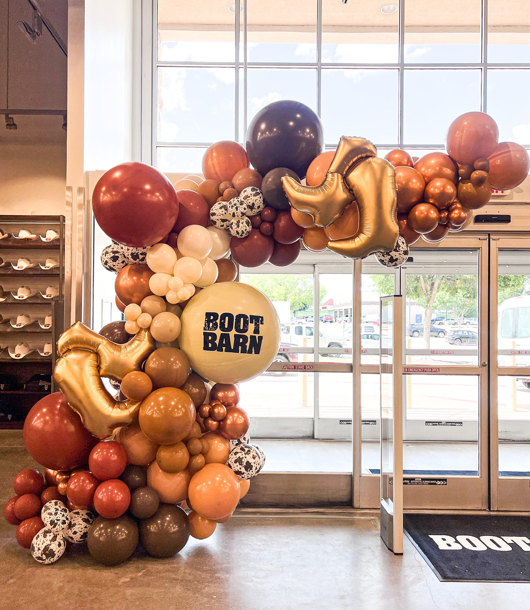 a giant balloon arch in the shape of a horse with a number of balloons attached to it in front of a window