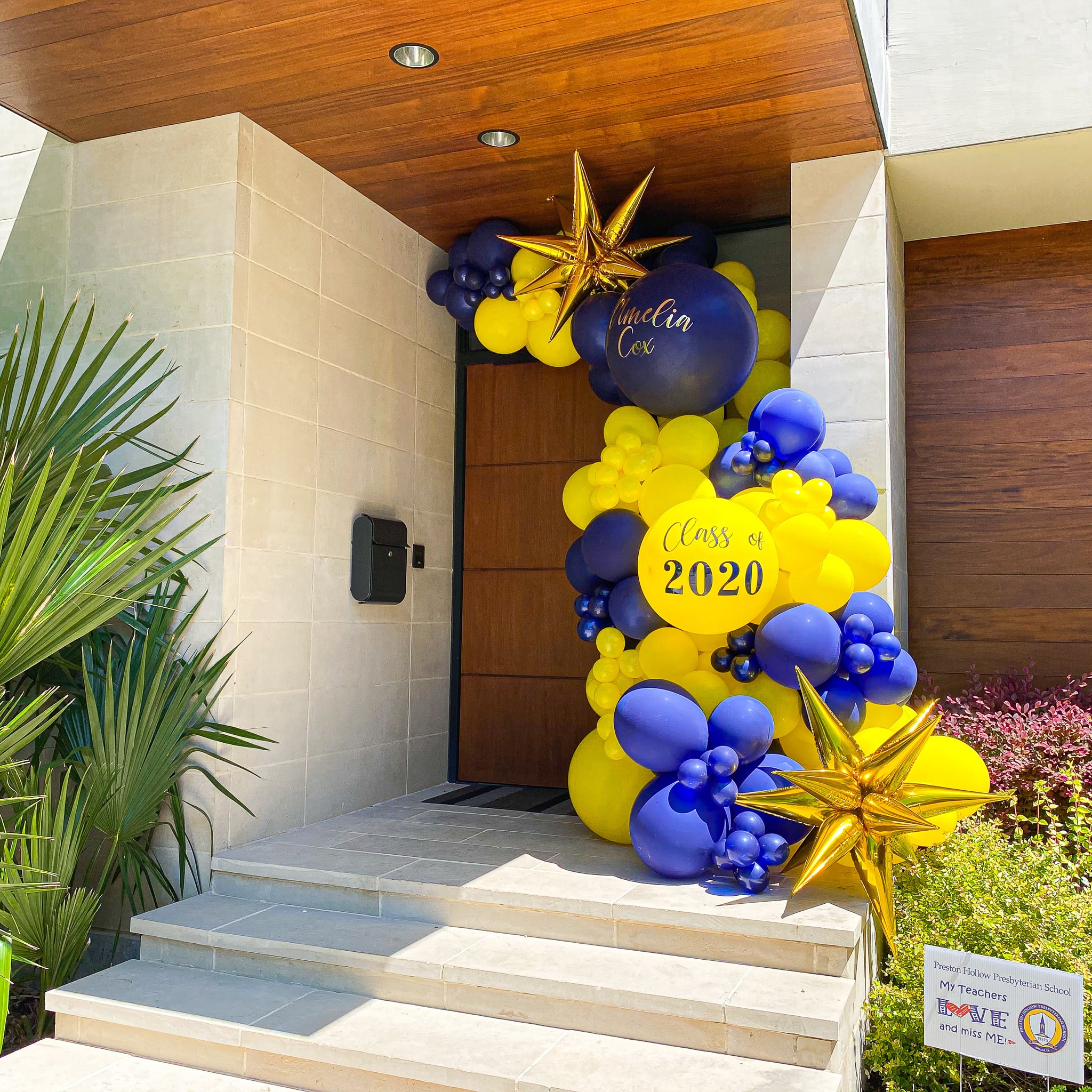 a bunch of balloons are on the steps outside of a house that is decorated for a new year's eve