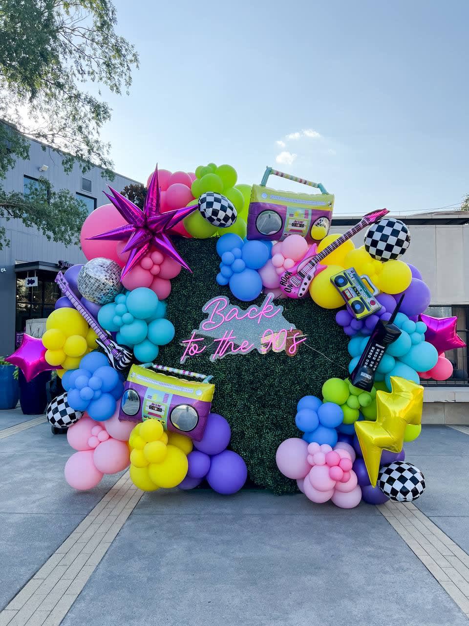 a bunch of balloons are arranged in the shape of a car with a boombox on top of it