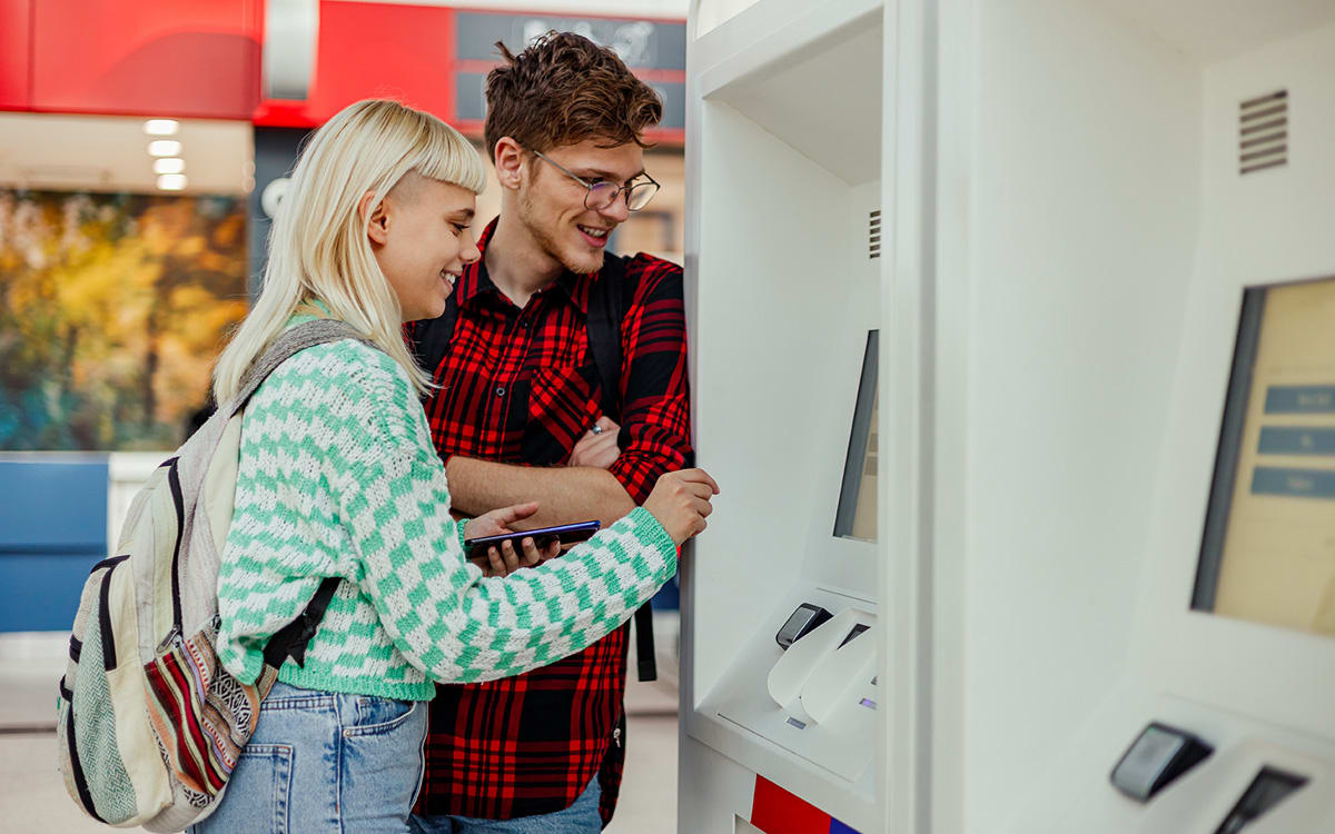 Et ungt par tar ut penger fra en minibank