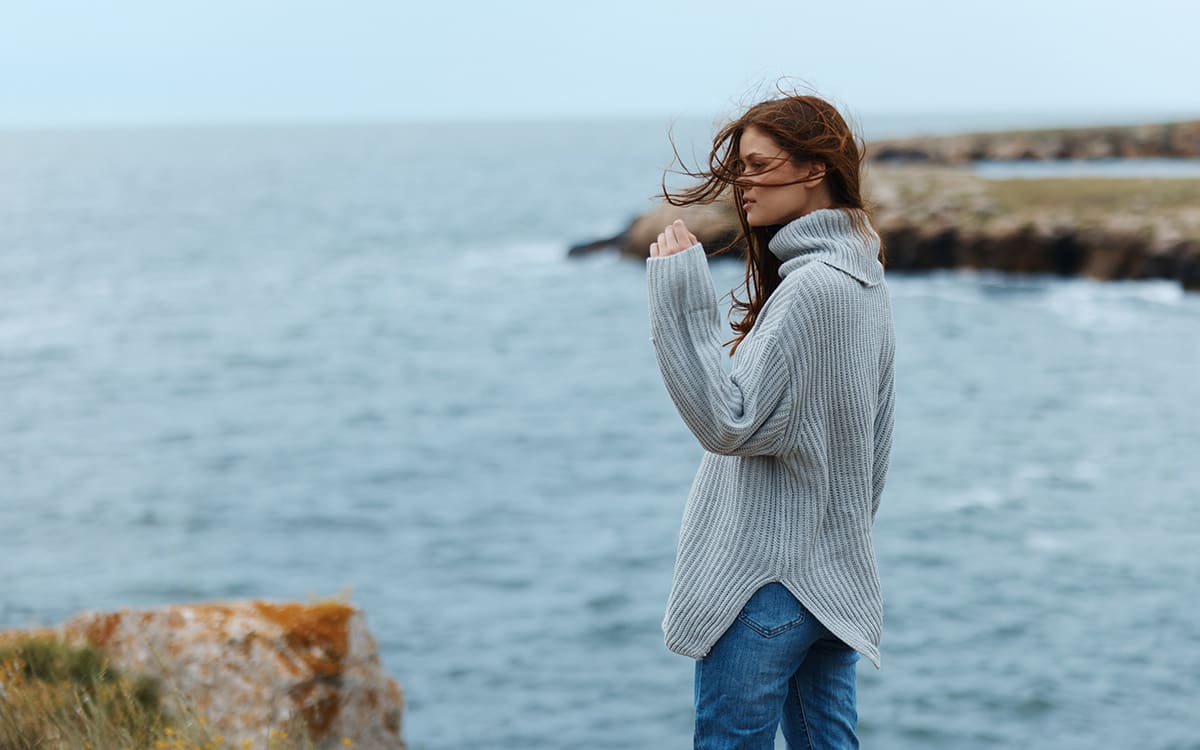 Ung kvinna som tittar ut över havet