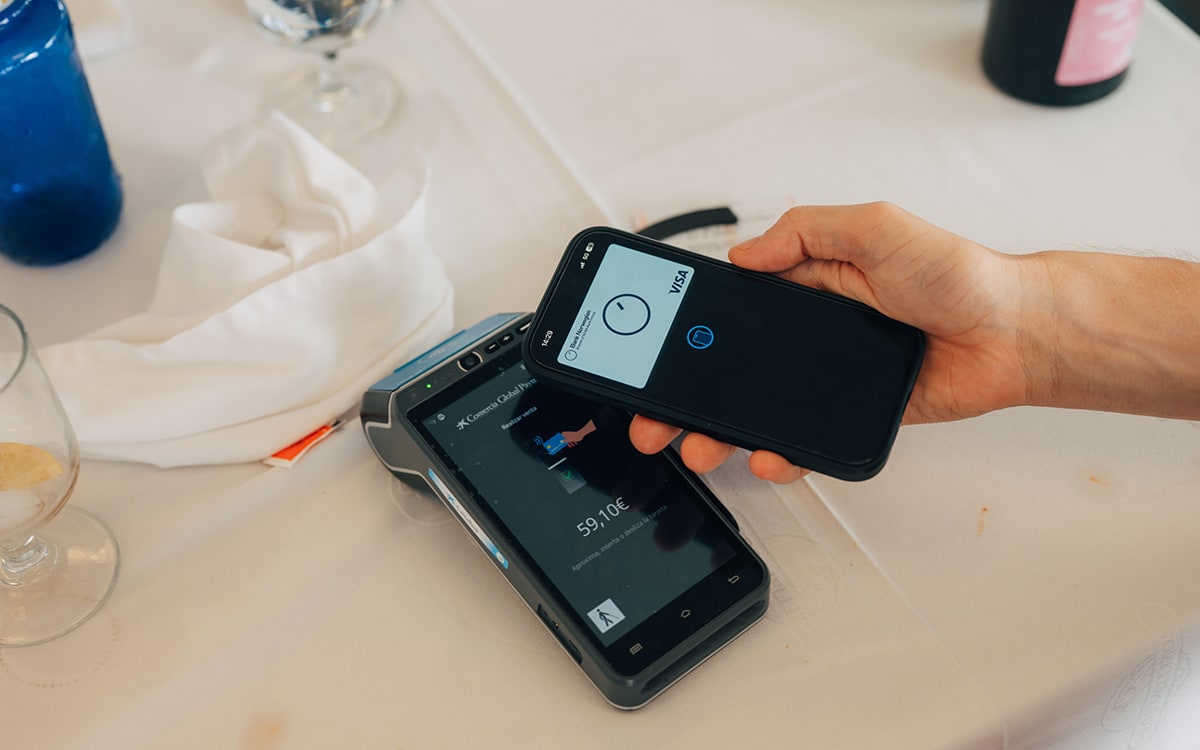 Kontaktlös mobilbetalning med Bank Norwegian Visa-kort mot en betalterminal på en restaurang