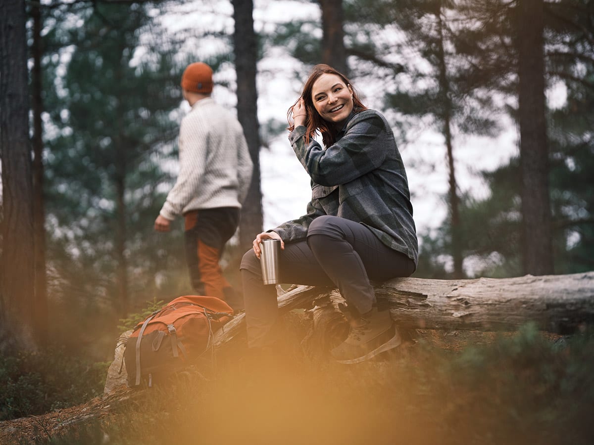 Glad kvinne i skogen.