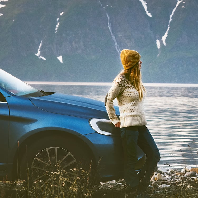 Woman leaning against a car