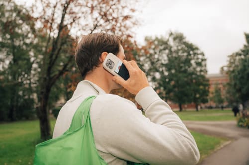 Mann som snakker i telefonen i en park, en påminnelse om å være obs på telefonsvindel og phishing