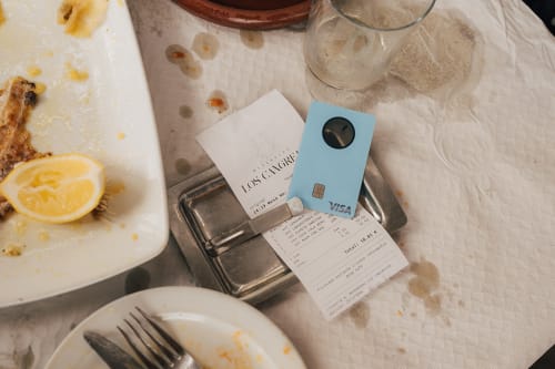 Bank Norwegian Visa-kort og kvittering på et restaurantbord etter betaling i utlandet