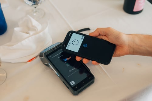 Kontaktløs mobilbetaling med Bank Norwegian Visa-kort mot en betalingsterminal på en restaurant