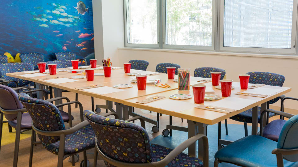 table set with individualized watercolor paint stations near the window of a brightly lit room