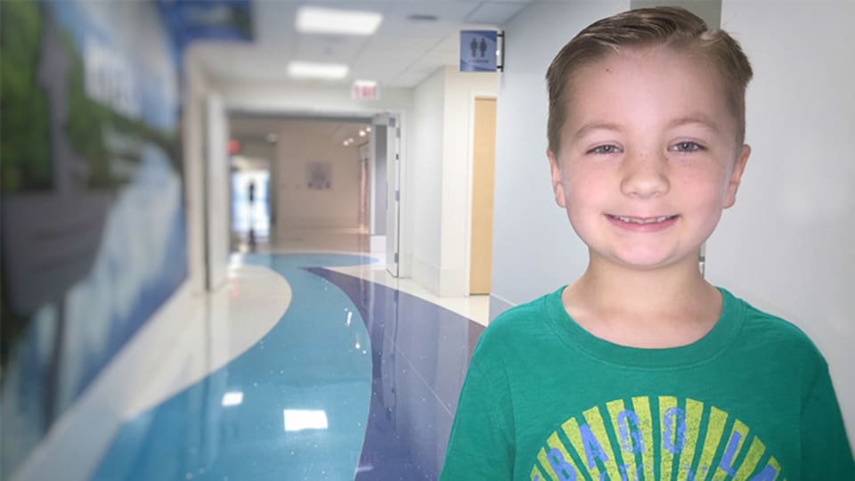 young male patient standing in the hallway of Wolfson Children's Hospital