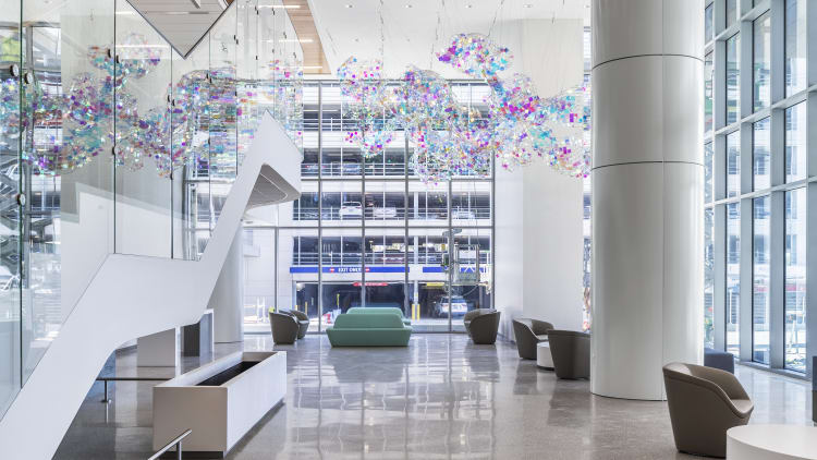 the 2-story lobby atrium of the critical care tower with shiny floor, grand staircase and colorful art mosaic hanging from the ceiling