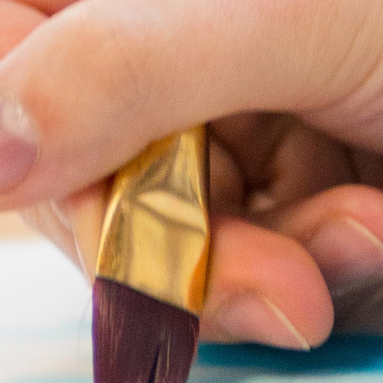 close up of hands painting a face on a piece of paper